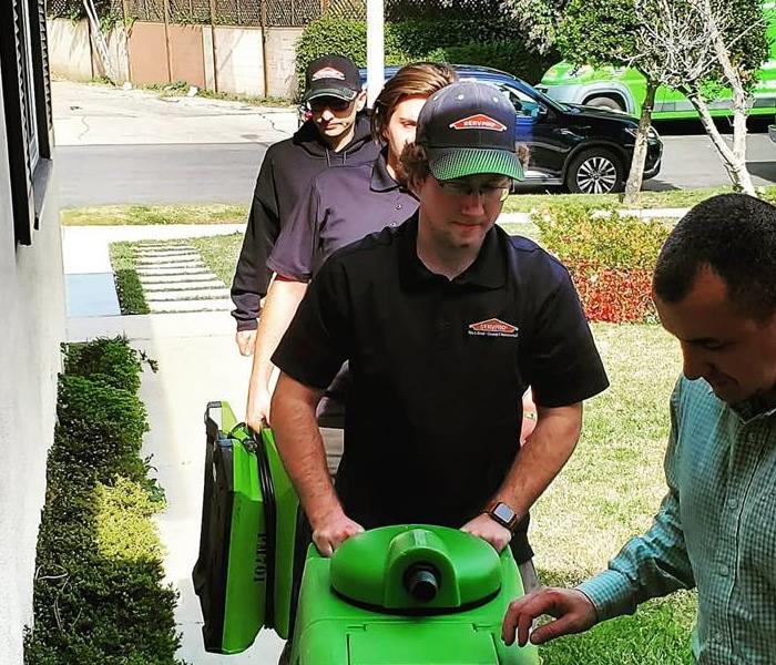 SERVPRO employees bringing equipment to a water loss
